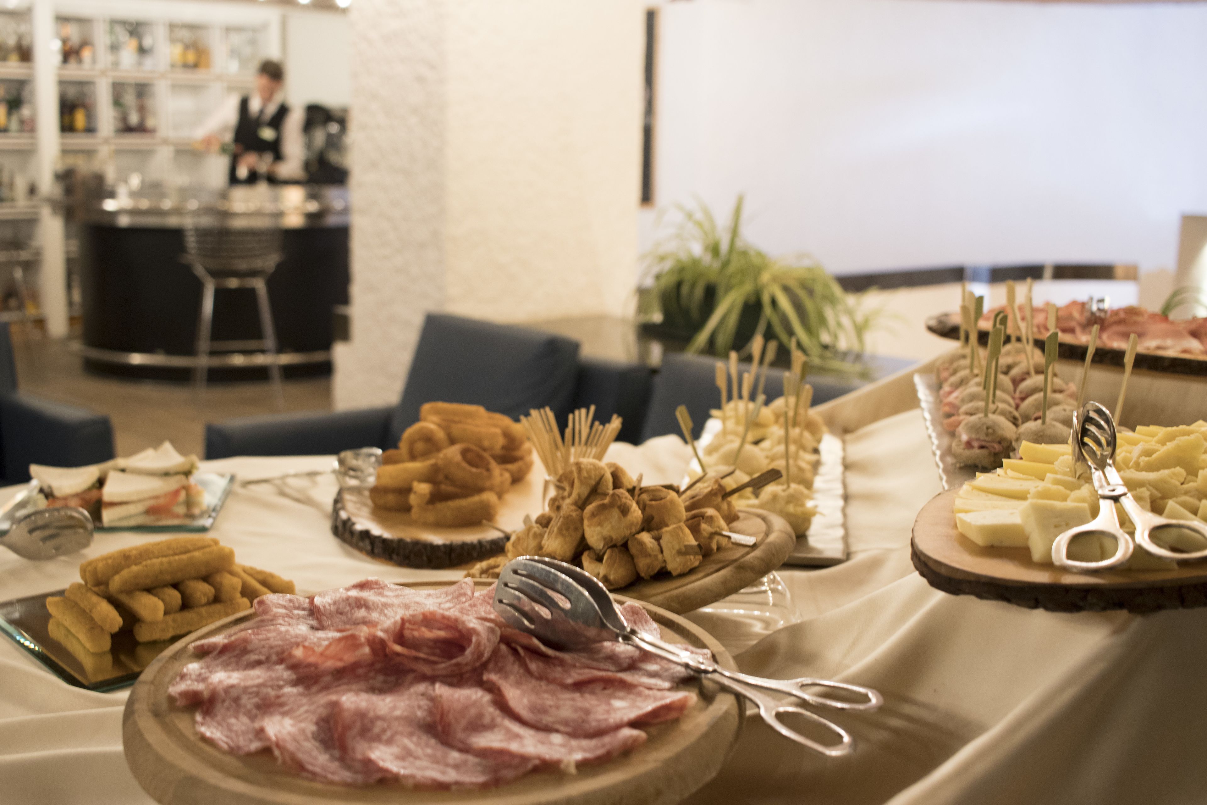 Una mesa de buffet con diversos alimentos, incluyendo carnes, quesos y galletas.