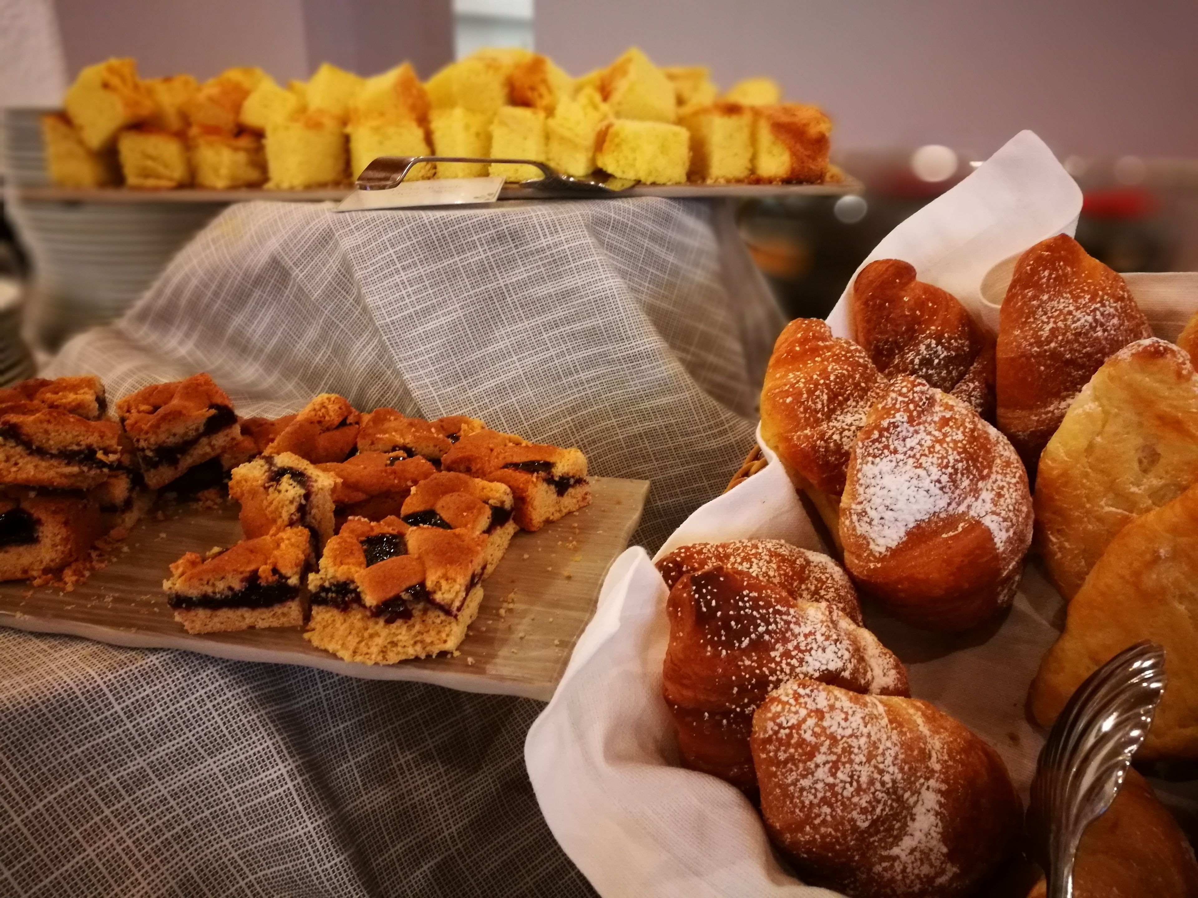 Buffet amb diferents productes de forneria, com ara pastissos, muffins i pastisseria.