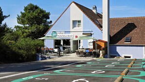A hotel with outdoor seating and a sign indicating it is a restaurant. - Brit Hotel Le 940 Le Touquet – Etaples (Etaples)