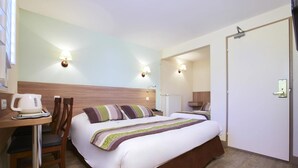 A hotel room with a bed, bedside table, chair, and a desk with a kettle. - Brit Hotel Le 940 Le Touquet – Etaples (Etaples)