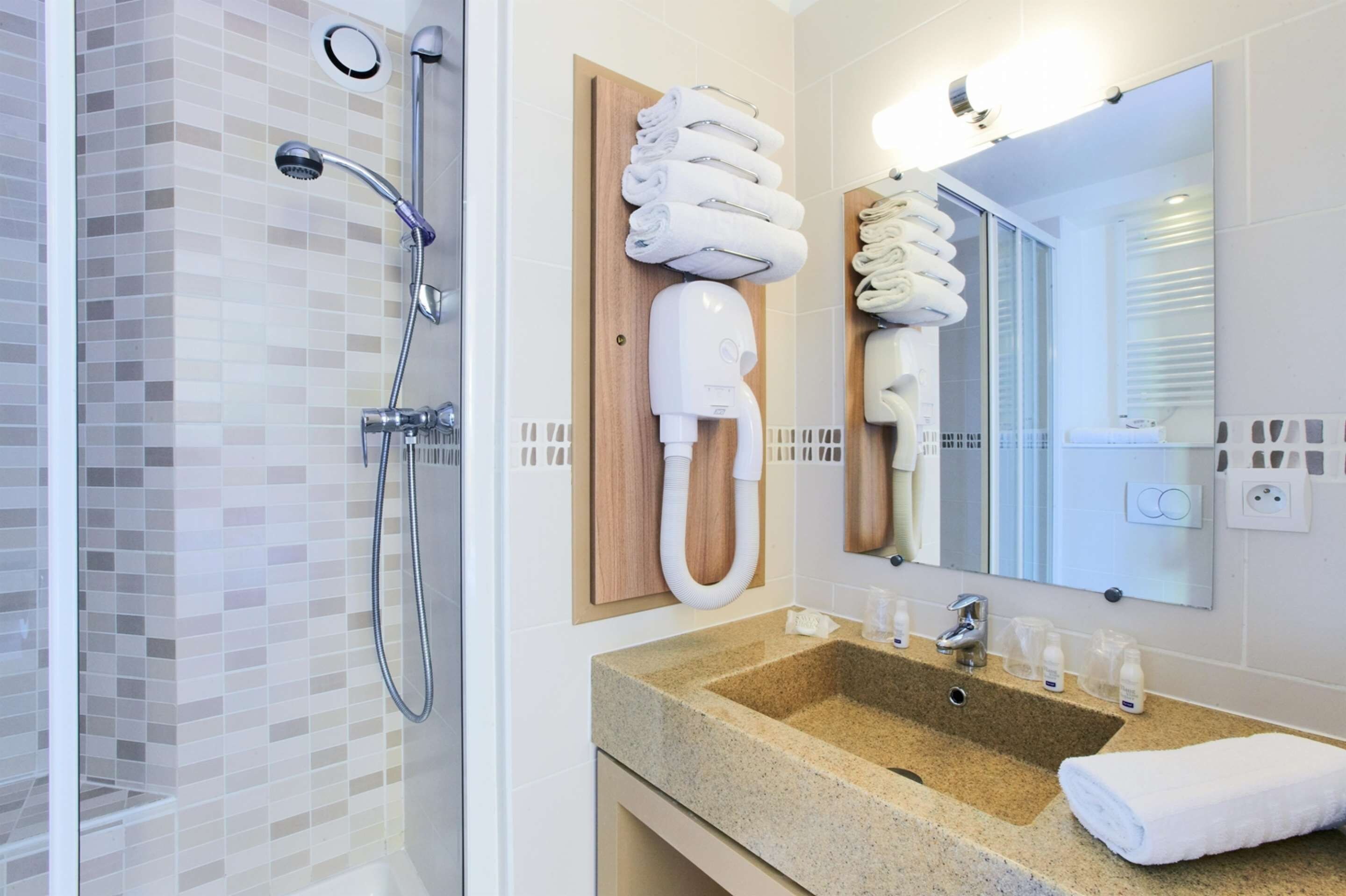 Une salle de bain moderne avec une douche à parois de verre, un meuble-lavabo et un miroir au-dessus.