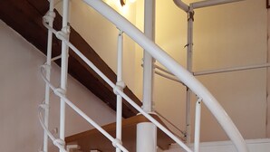 A white spiral staircase with wooden steps and white railings. - Hôtel Media (Paris)