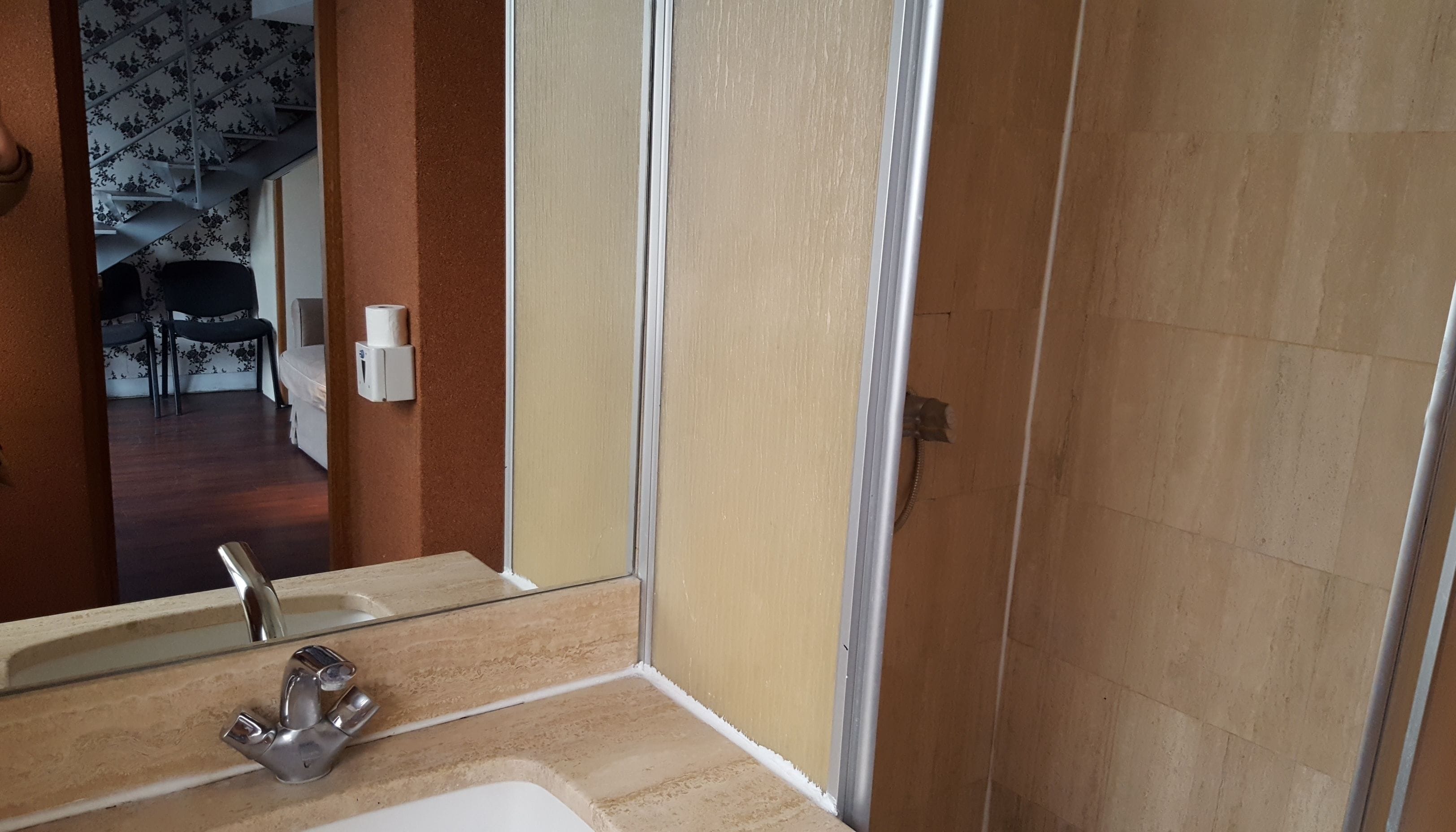 Un baño con lavamanos, espejo y retrete.