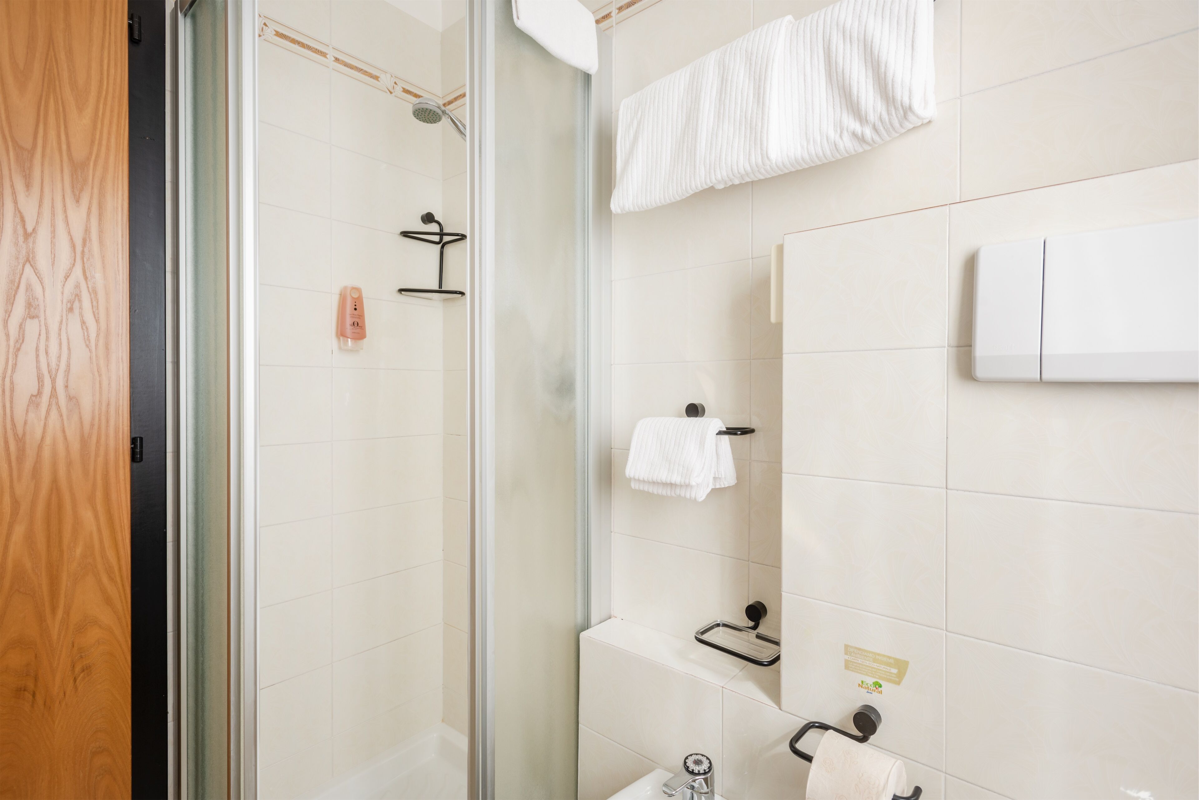 Une salle de bain moderne avec une douche à parois de verre, un lavabo blanc et un porte-serviettes.