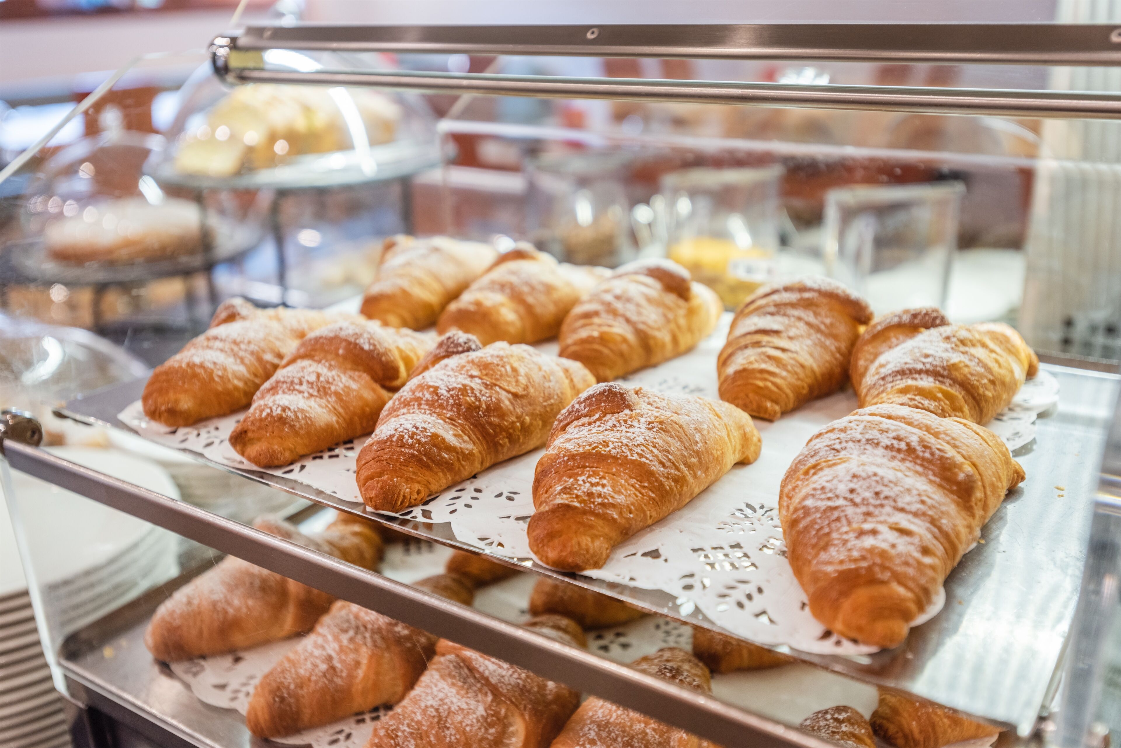 A bakery display case with various pastries, including croissants and other baked goods.