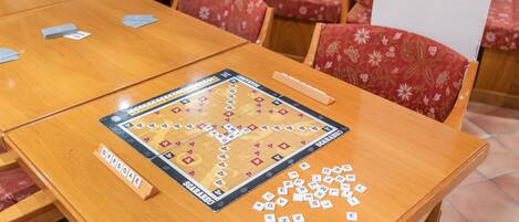 Un juego de mesa montado sobre una mesa de madera, con una tarjeta identificadora que dice 'OFFISOE' y fichas de letras dispersas.