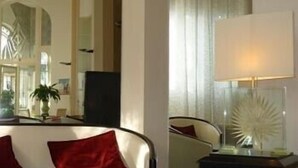 A hotel room with a bed, a nightstand, a lamp, and a mirror.