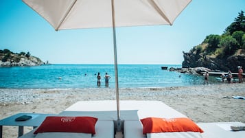 位於海灘上、遮陽傘、海灘浴巾、排球