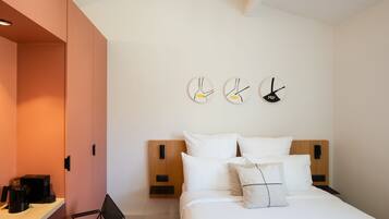 Un dormitorio moderno con cama, mesitas de noche y un reloj en la pared.