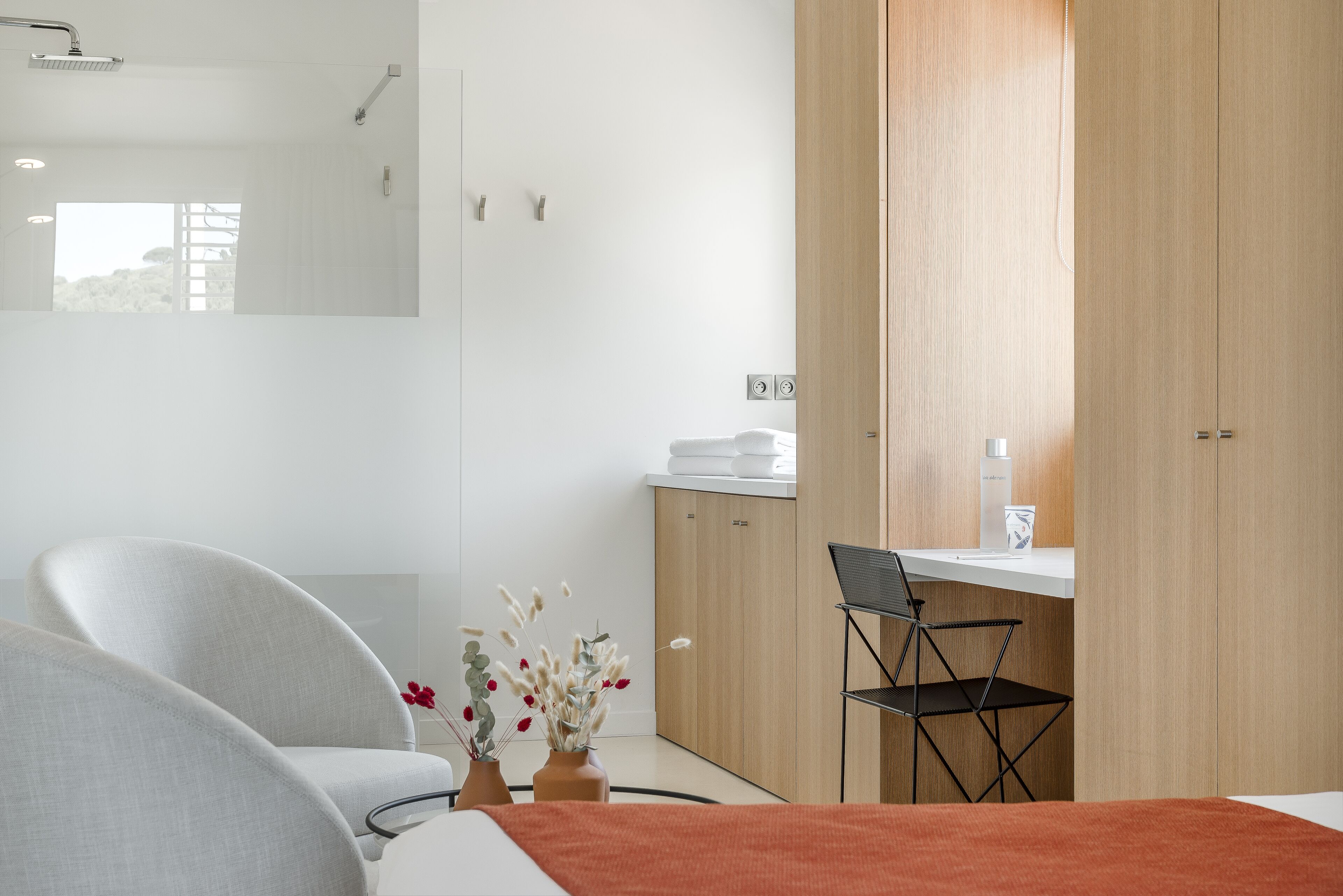 Una habitación de hotel moderna con una cama, un escritorio, una silla y un armario.
