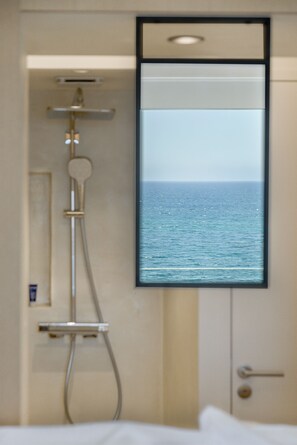Habitación superior, balcón, vista al mar | Baño | Regadera, regadera tipo lluvia, amenidades de baño de diseñador 