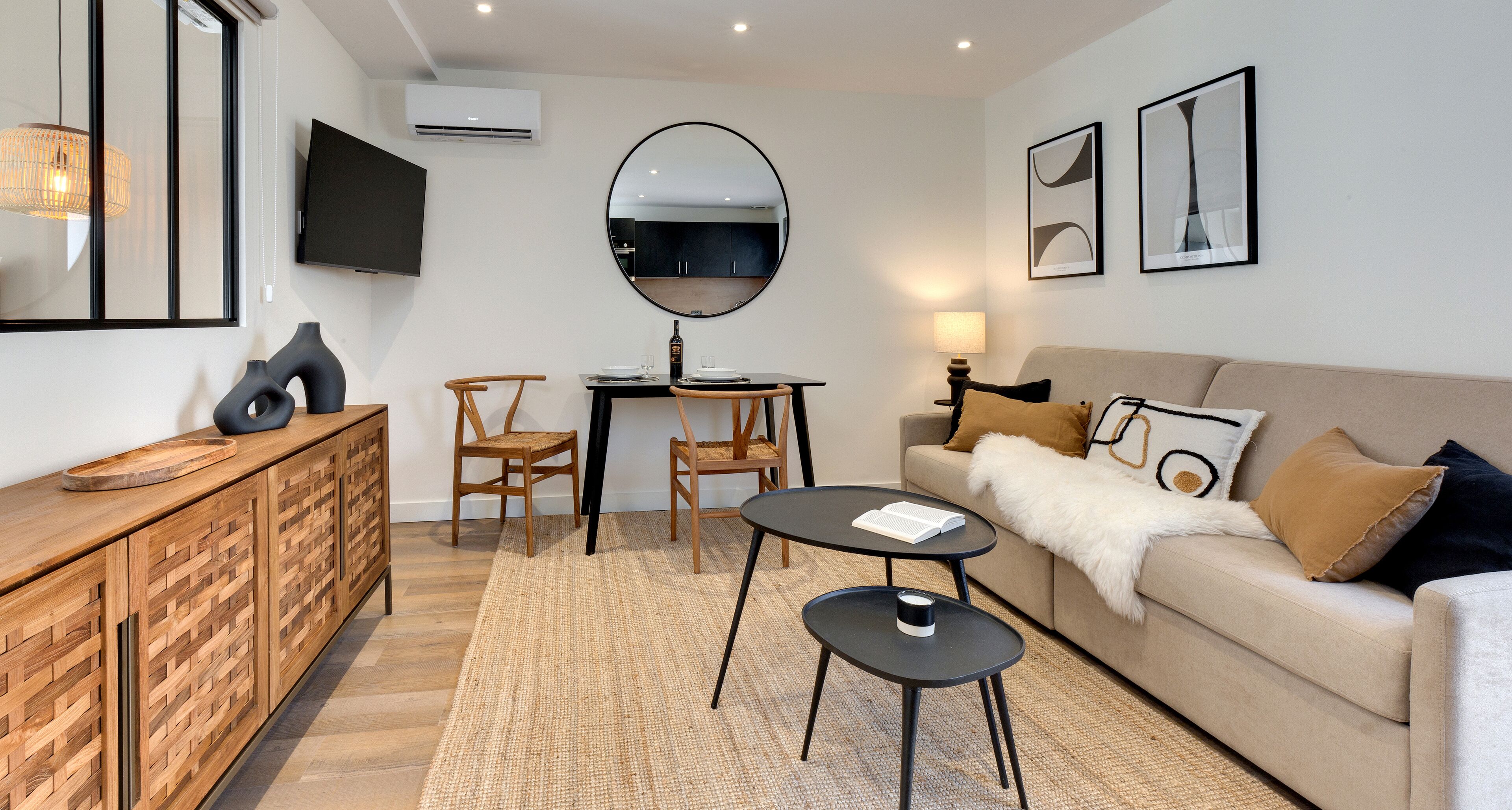 Una sala de estar moderna con un sofá, dos sillones, una mesa de centro, un televisor y una mesa de comedor.