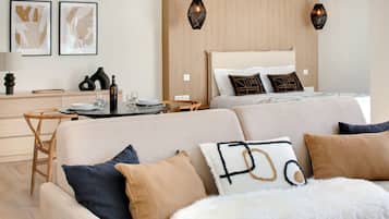Une chambre d’hôtel moderne, dotée d’un canapé, d’une table à manger et d’un lit agrémenté d’oreillers décoratifs.