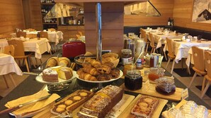 A buffet spread with various pastries, cakes, and condiments. - Hotel Ariston (Pinzolo)