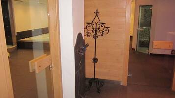 Una camera d'albergo con un letto, un pavimento in legno e una rastrelliera metallica.
