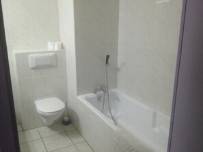 A small, clean bathroom with a toilet, a sink, and a bathtub.