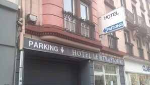 Entrada de hotel con un letrero que indica un estacionamiento abajo.