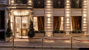 A multi-story hotel with ornate balconies, a grand entrance, and a well-lit facade. - Hôtel Kleber Paris & Spa (Paris)