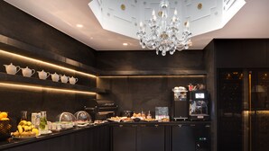 A modern kitchen with a marble floor, a chandelier, and a coffee machine. - Hôtel Kleber Paris & Spa (Paris)