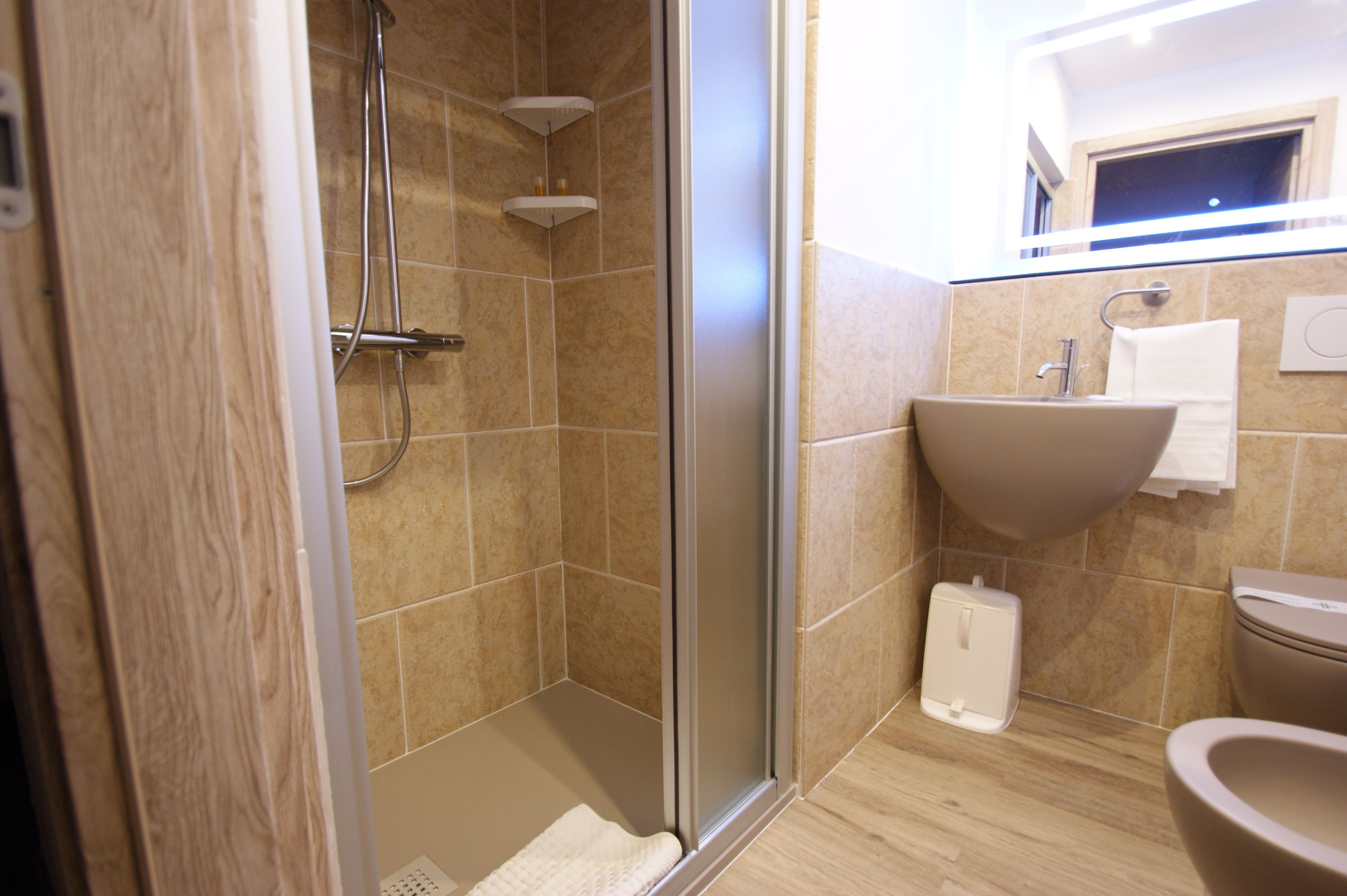 Une salle de bain moderne avec une douche à parois de verre, un lavabo et des toilettes.