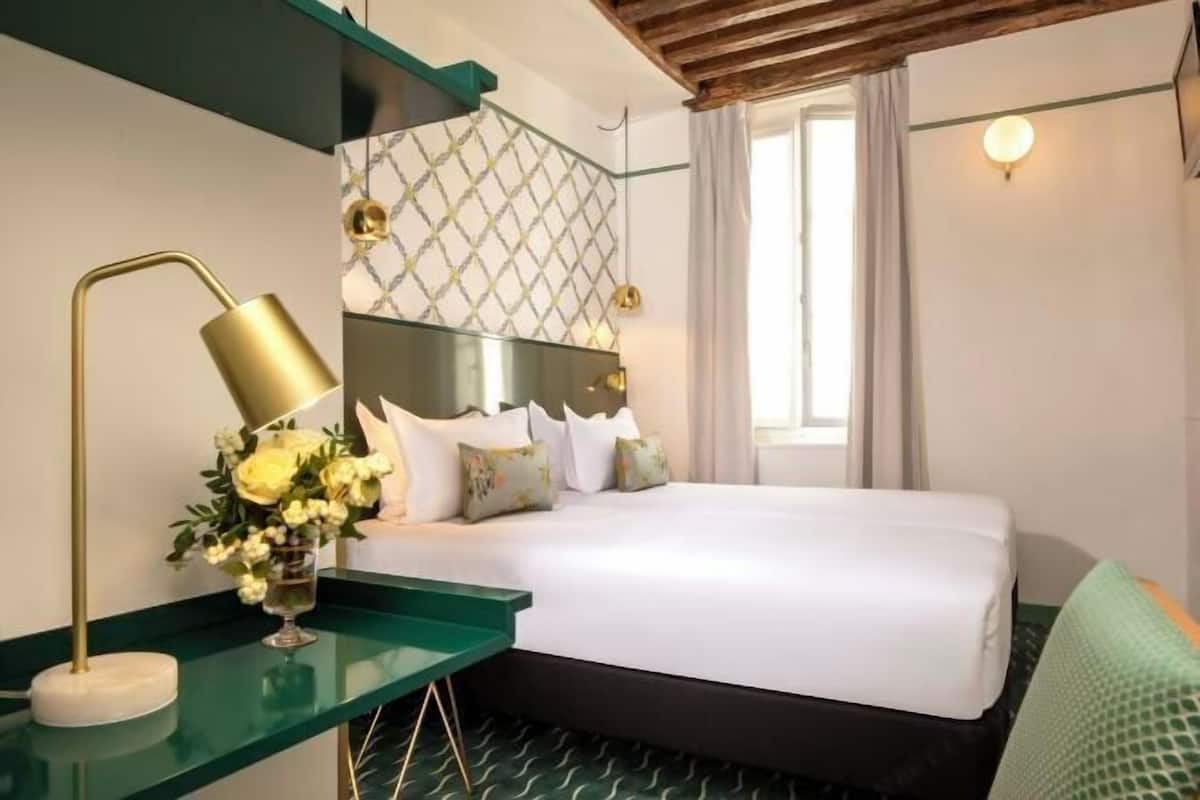 Ein Hotelzimmer mit einem Bett, einem Nachttisch mit Lampe und einer Wandverkleidung.