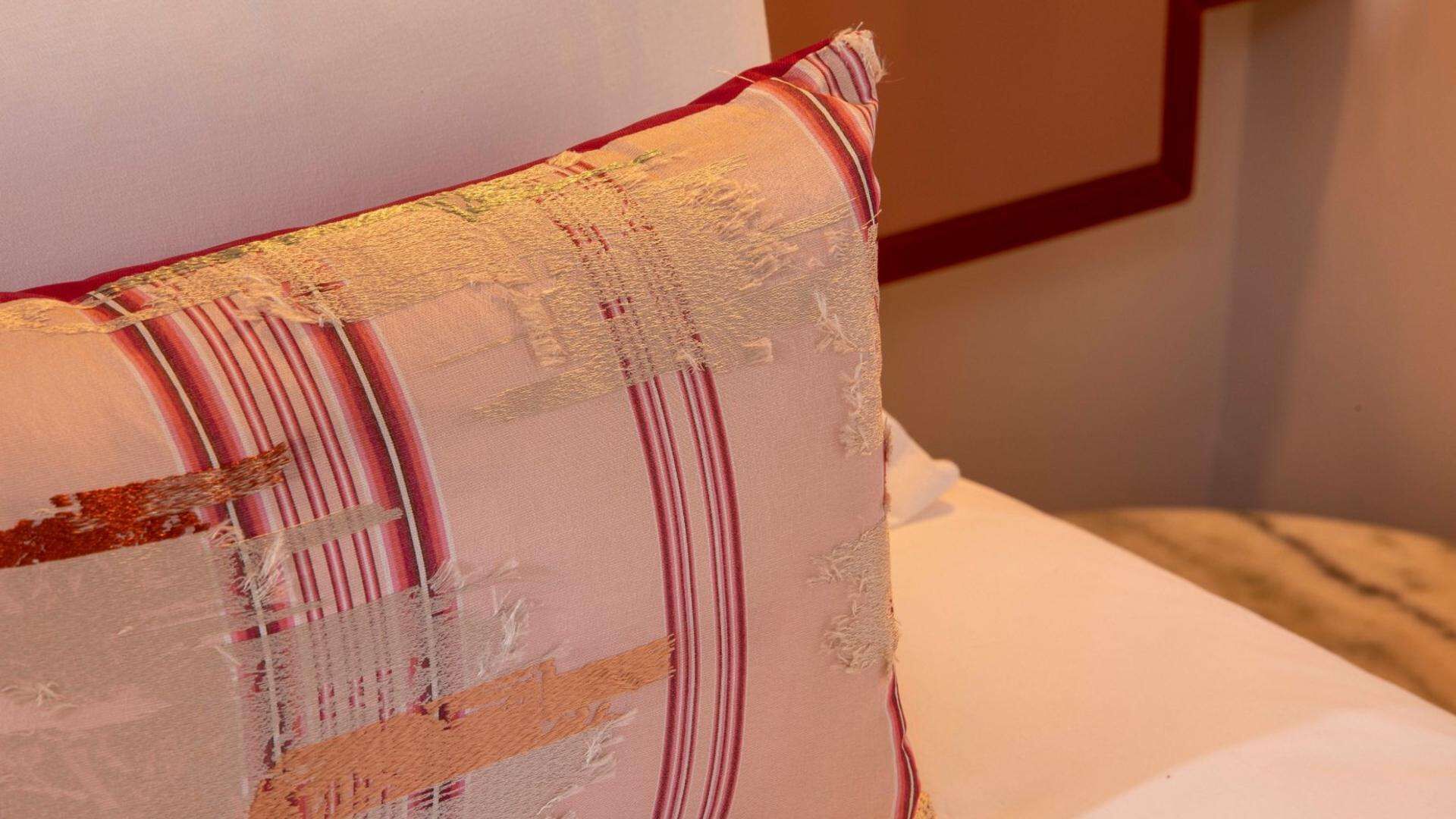 A close-up of a pillow with a striped pattern and a textured surface.