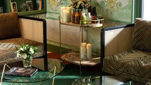 A cozy seating area with patterned sofas, a glass coffee table, and a small side table with a book and a vase of flowers. - Hôtel des Deux-Iles - Notre-Dame (Paris)
