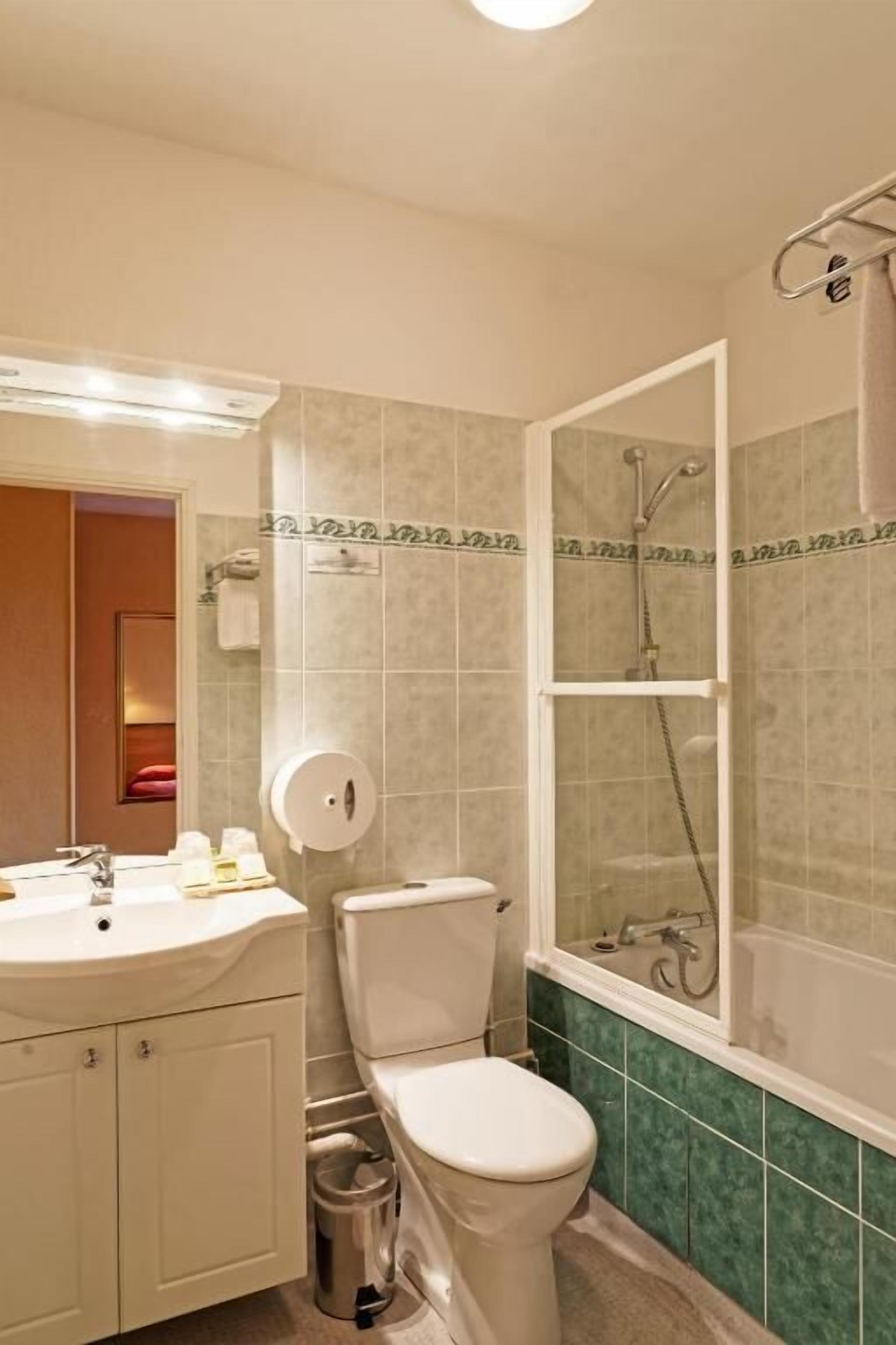 Un baño con inodoro, lavamanos y ducha.