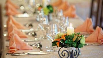 A table set with glassware, a candle, and a floral centerpiece.