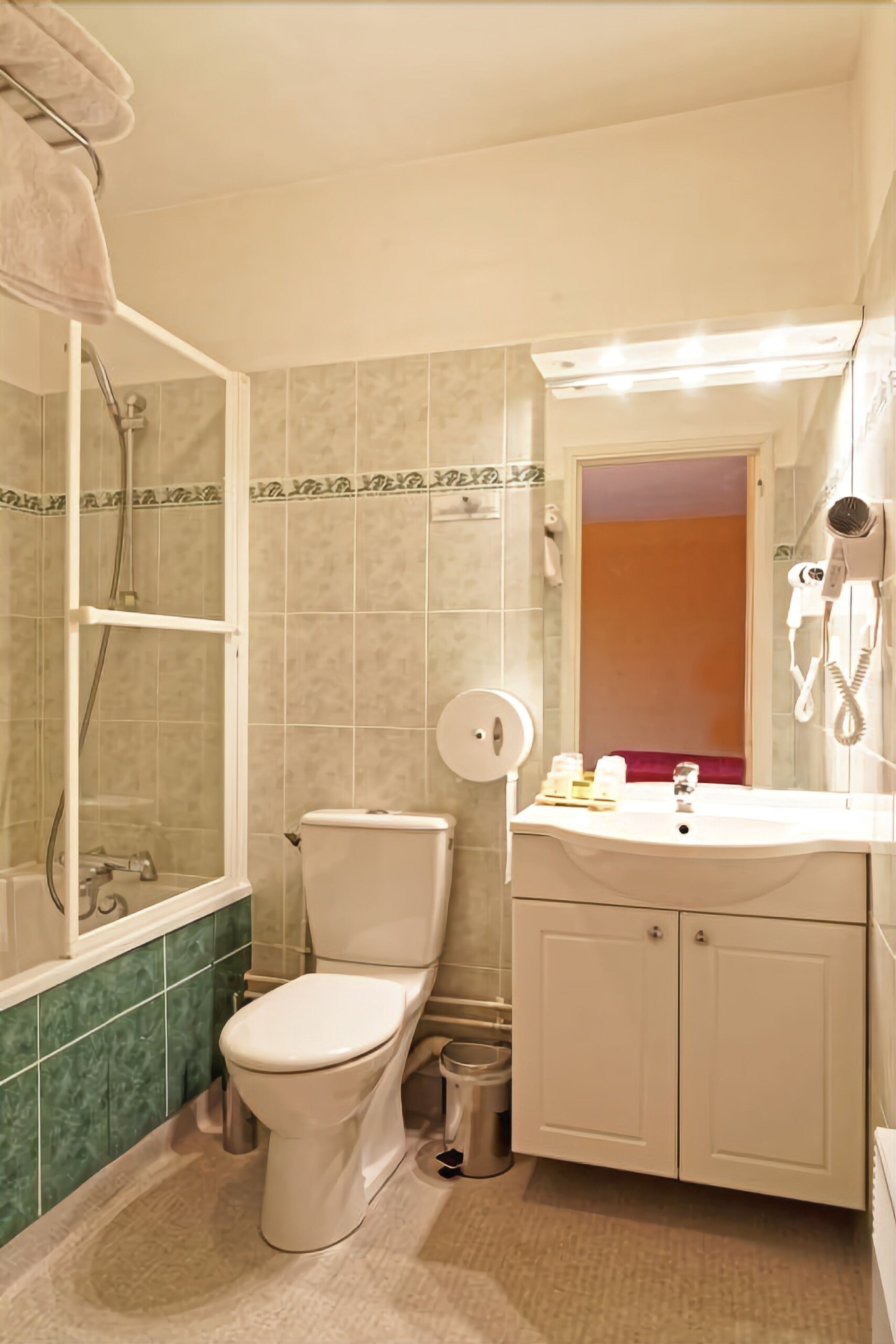 A bathroom with a toilet, shower, and sink.