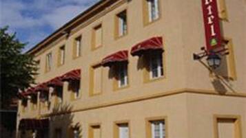 A building with a yellow facade, multiple windows, and red awnings.
