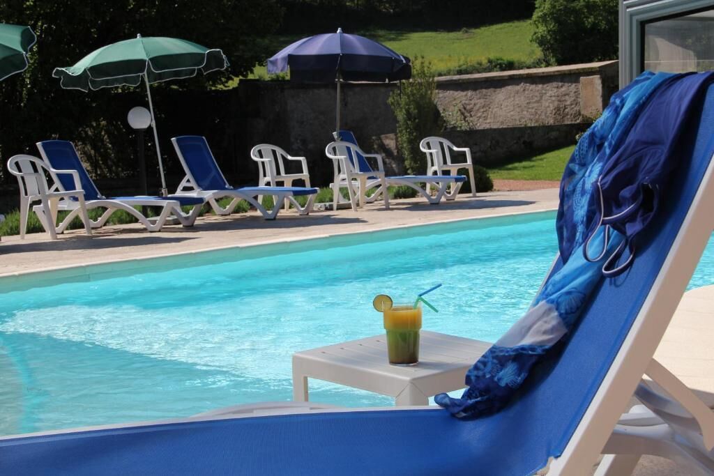 A pool area with lounge chairs and umbrellas.