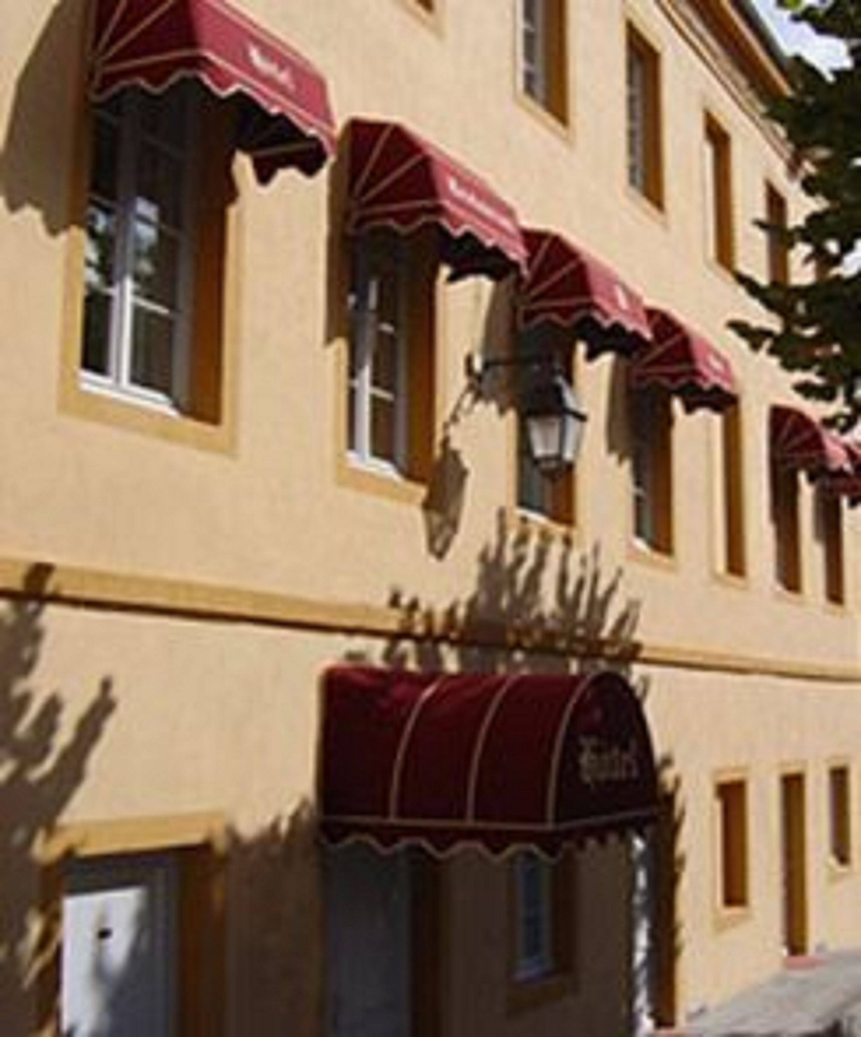 A building with multiple windows, each with a red awning.