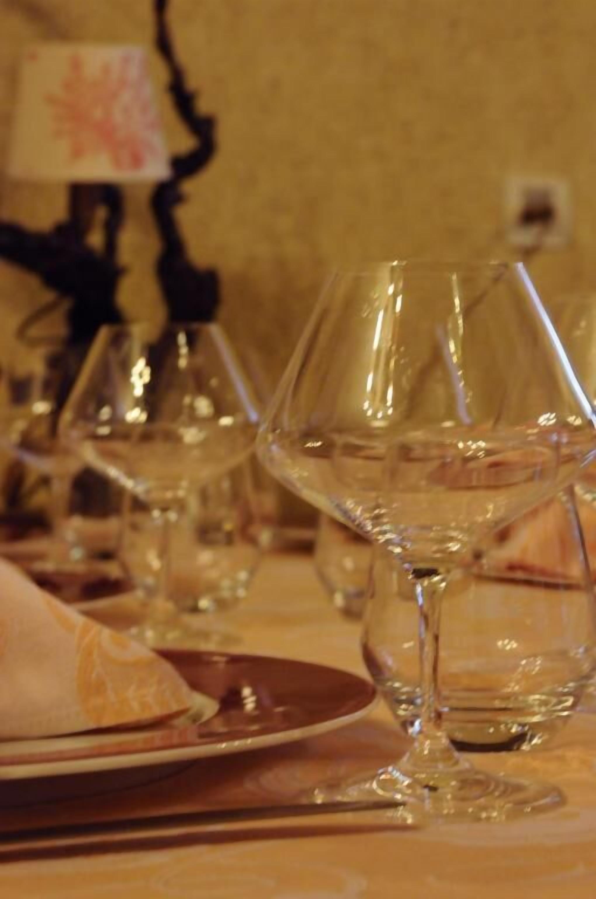 Un tavolo apparecchiato con bicchieri da vino e piatti, che suggerisce una sala da pranzo.