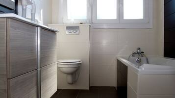 Ein modernes Badezimmer mit Toilette, Waschbecken und Badewanne.