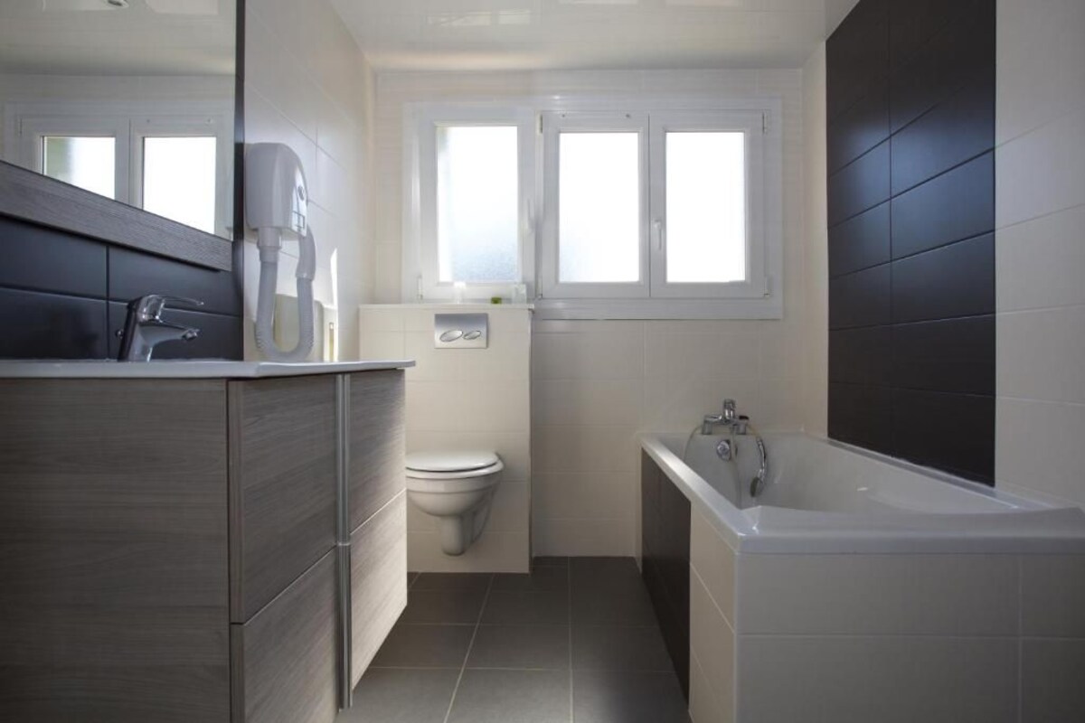 Uma casa de banho moderna com sanita, lavatório e banheira.
