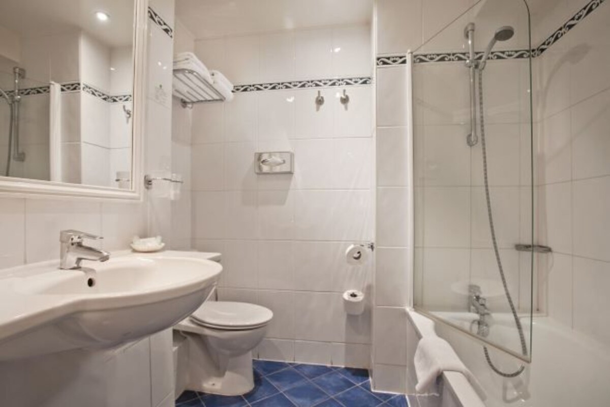 Une salle de bain avec un lavabo, des toilettes et une douche.