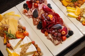 Eine Platte mit verschiedenen Käsesorten, Obst und Nüssen.