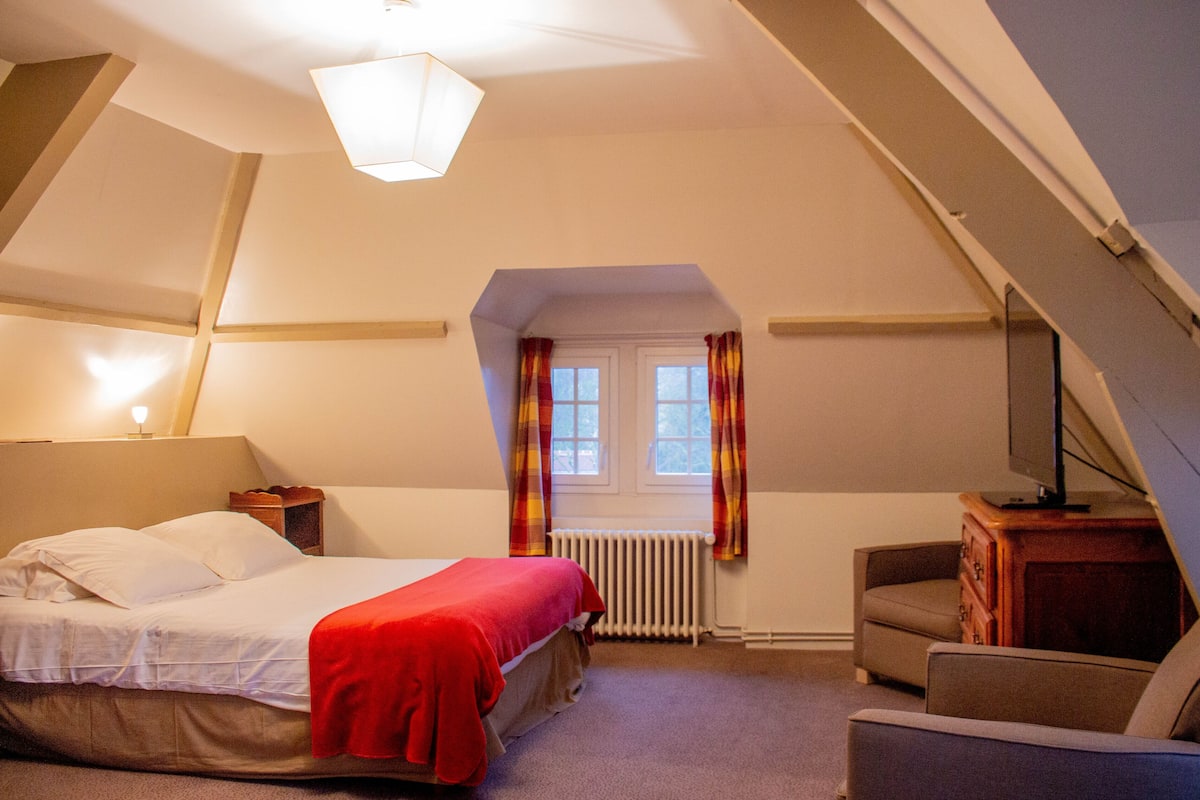 Une chambre à coucher avec un lit, une chaise, un radiateur et une fenêtre avec des rideaux.