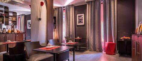 Un hall d’hôtel moderne doté d’un bar, de différents espaces de détente et offrant une vue sur l’extérieur grâce à de grandes fenêtres.
