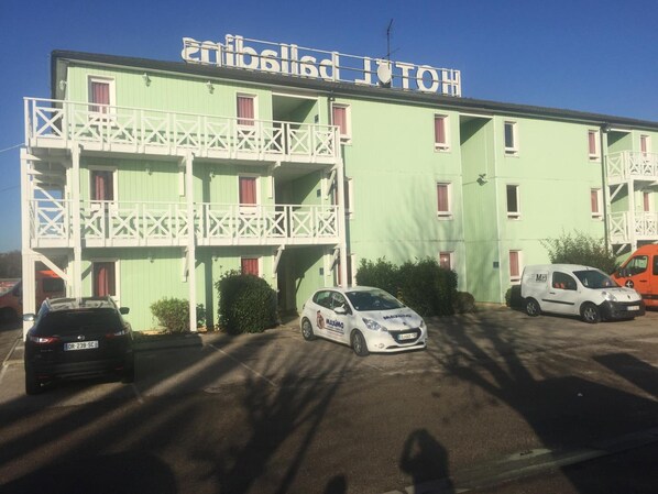 A building with a sign that reads "embellished MICHIGAN". - Hotel initial by balladins Roissy CDG / Saint-Mard (Saint-Mard)