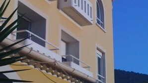 A building with the name 'ARADIS' on the facade, featuring balconies and arched windows. - Hôtel Paradis (Bormes-Les-Mimosas)