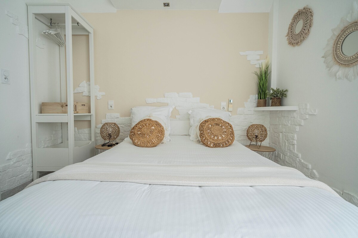 A bedroom with a bed, two bedside tables, a wardrobe, and decorative wall elements.