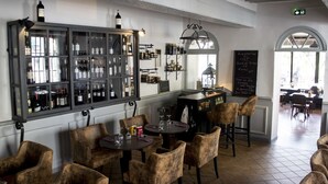 Een restaurantinterieur met een wijnrek, een bar en zitplaatsen.