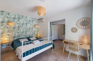 Un dormitorio con cama, lámparas de noche, un escritorio y una silla.