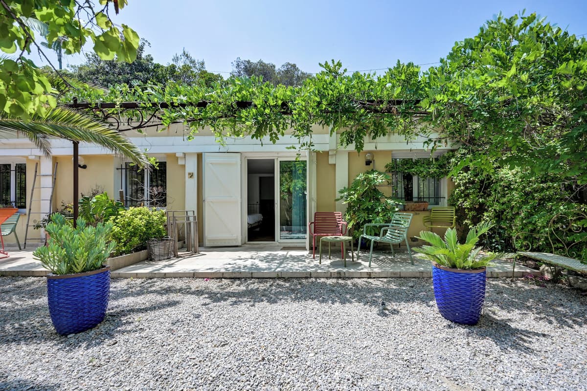 Un bâtiment doté d’un patio couvert, de plantes en pot et de sièges d’extérieur.