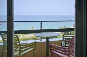 Un balcón con mesa y sillas, con vista al mar.