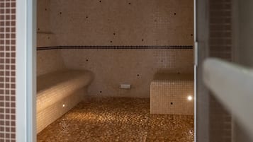 space with a bench and table, featuring a tiled floor and walls.