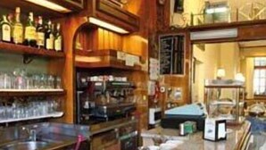 A bar area with a granite countertop, shelves with bottles, and a variety of bar tools. - Hotel Elena (Stresa)