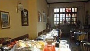 A buffet setup with various food items and a pitcher of orange juice. - Hotel Elena (Stresa)